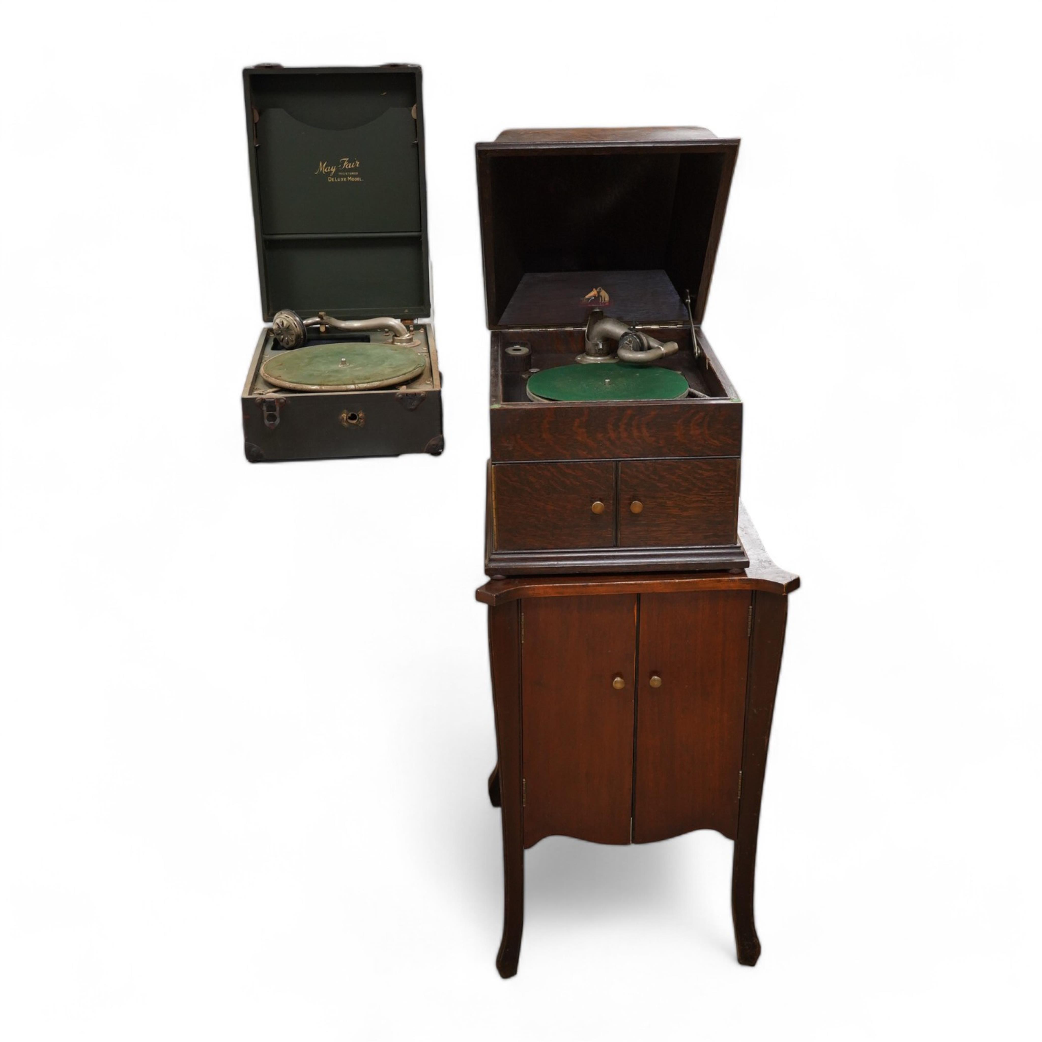 Two gramophone players; an oak cased HMV tabletop gramophone on a similar style mahogany gramophone record stand, height of stand 72.5cm, together with a May-Fair Deluxe Model portable gramophone player. Condition - poor